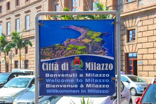 MILAZZO, SICILY, Italy - 03 October 2023. Selective focus on the welcome sign in the centre of Milazzo with an outline map of the town area over blurred city Hall background.