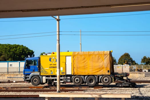 MILAZZO, SICILY, Italy - 03 October 2023. Mobile rail welding robot APT 1500 RL is driven over the road to the construction site, placed on the track, the rail ends automatically aligned and pulled and welded.
