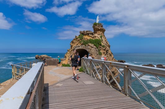 Biarritz, France, July 03, 2023: Tourists at the rocher de la vierge (virgin mary rock) in Biarritz. Aquitaine, Basque Country, France.