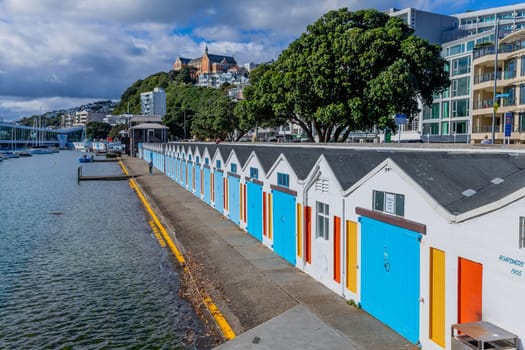 Wellington, New Zealand - 12 May 2023: Boat sheds, in a row, with their quaint blue doors, on Wellington's Oriental Bay. New Zealand.