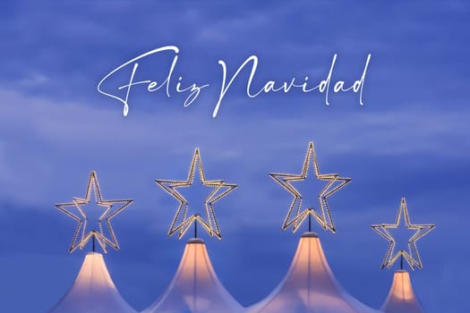 Wonderful x-mas season scene for visual or greetings card. Beautiful market tents with magic orange stars and blue sky at evening time.