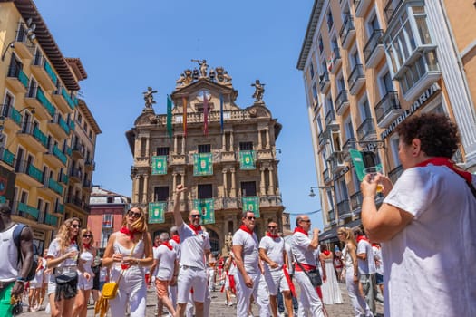 Pamplona, Spain: 09 July 2023: People celebrate San Fermin festival in traditional white abd red clothing with red necktie, Pamplona, Navarra, Spain.