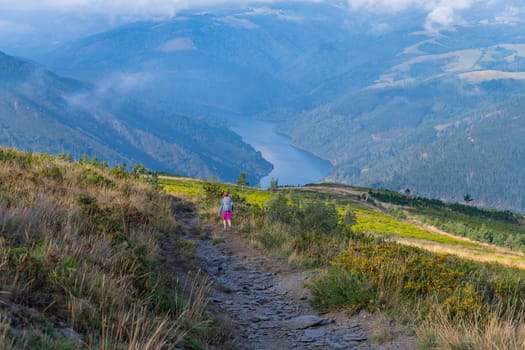 Asturias, Spain: 19 July 2023: Pilgrim on the Camino de Santiago (The Way of Saint James) among the fog morning light at the mountains. Primitivo. Asturias, Spain