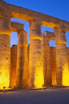 Illuminated columns of Karnak temple.. Night photo. Luxor, Egypt. Vertically.