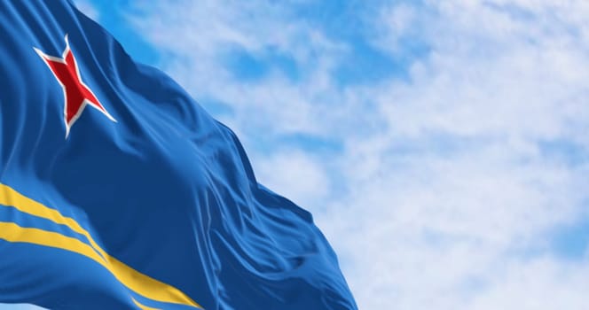 Flag of Aruba waving in the wind on a clear day. Light blue field, 2 yellow stripes, 4-pointed red star. Colors represent sea, abundance, peace, and origins. 3d illustration render. Selective focus