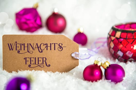 Label With German Text Weihnachtsfeier, Means Christmas Party In English, White Snow Background With Purple Christmas Balls, Christmas And Winter Decor