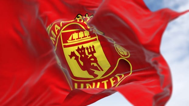 Manchester, UK, Oct. 2 2023: Close-up of Manchester United Football Club flag waving on a clear day. Premier League pro team. Illustrative editorial 3d illustration render. Selective focus