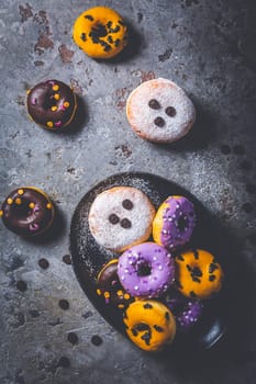 Halloween donuts and Berliner with assorted frosting and sugar sprinkles for Halloween and carnival