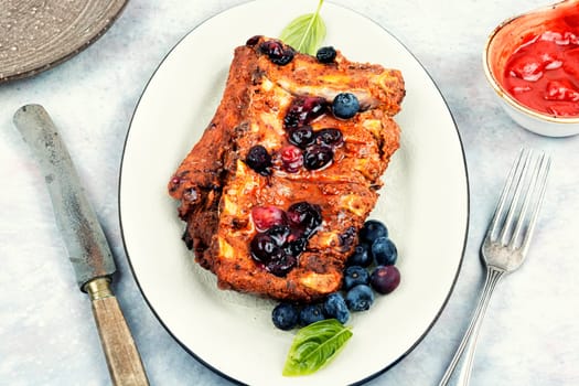 Fried pork ribs with blueberry sauce. Top view
