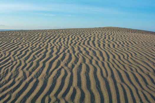 Lines in the desert sand with blue sky