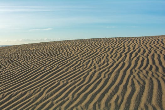 Lines in the desert sand with blue sky