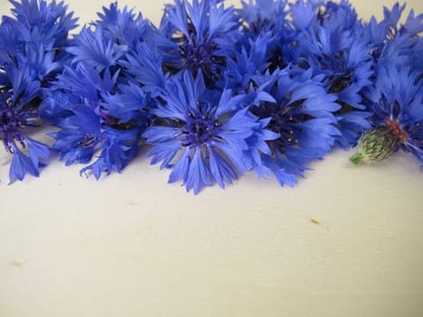 Still life with blue cornflowers flowers on a wooden board