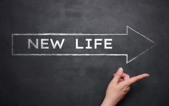Arrow with the inscription in white chalk New life. Concept of starting a business, counting down a new time
