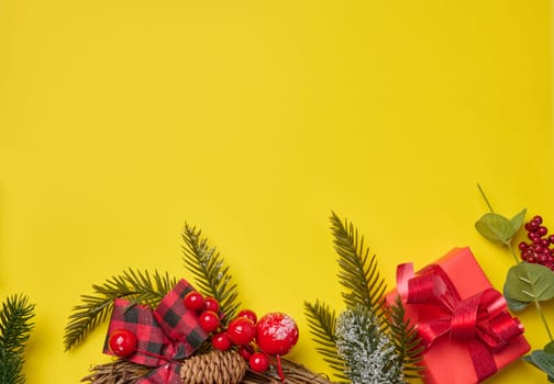 Christmas decor, gifts wrapped in red paper on a yellow background, top view. Copy space