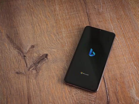 Lod, Israel - July 16,2023: Bing Browser app launch screen on smartphone on wooden background. Top view flat lay with copy space.