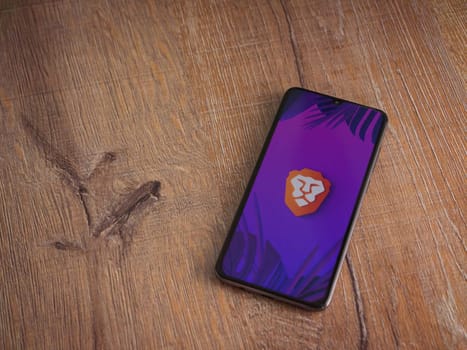 Lod, Israel - July 16,2023: Brave Private Browser app launch screen on smartphone on wooden background. Top view flat lay with copy space.