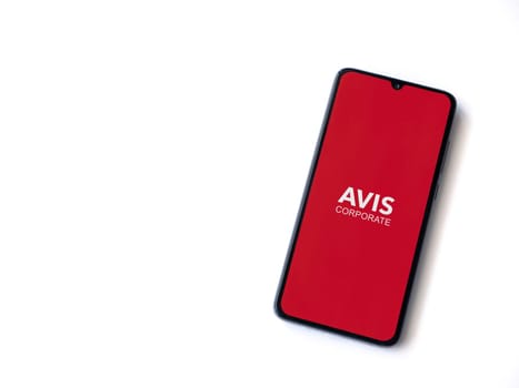 Lod, Israel - July 16,2023: Avis Corporate app launch screen on smartphone on white background. Top view flat lay with copy space.