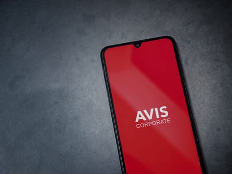 Lod, Israel - July 16,2023: Avis Corporate app launch screen on smartphone on dark marble stone background. Top view flat lay with copy space.
