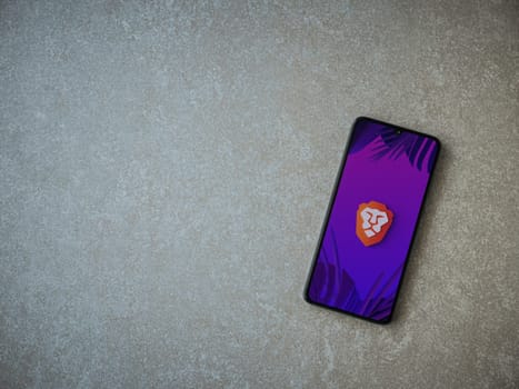Lod, Israel - July 16,2023: Brave Private Browser app launch screen on smartphone on ceramic stone background. Top view flat lay with copy space.