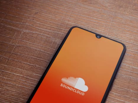 Lod, Israel - July 16,2023: SoundCloud app launch screen on smartphone on wooden background. Top view flat lay with copy space.