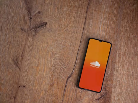 Lod, Israel - July 16,2023: SoundCloud app launch screen on smartphone on wooden background. Top view flat lay with copy space.