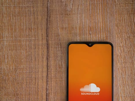 Lod, Israel - July 16,2023: SoundCloud app launch screen on smartphone on wooden background. Top view flat lay with copy space.