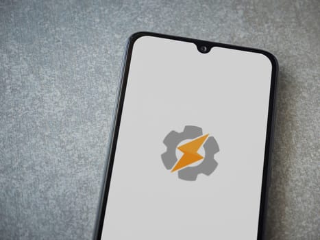Lod, Israel - July 16,2023: Tasker app launch screen on smartphone on ceramic stone background. Top view flat lay with copy space.