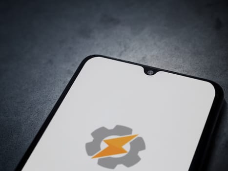 Lod, Israel - July 16,2023: Tasker app launch screen on smartphone on dark marble stone background. Top view flat lay with copy space.