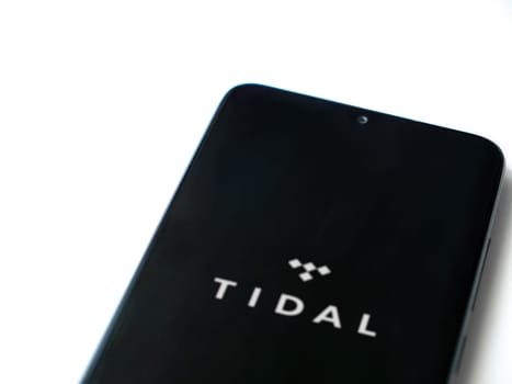 Lod, Israel - July 16,2023: TIDAL Music app launch screen on smartphone on white background. Top view flat lay with copy space.