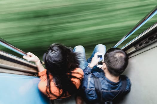 Couple traveling by train. Motion blured image creating impression of movement and speed. On the move.