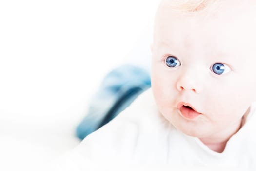Cute blonde little baby boy with blue eyes. Copy space on left.