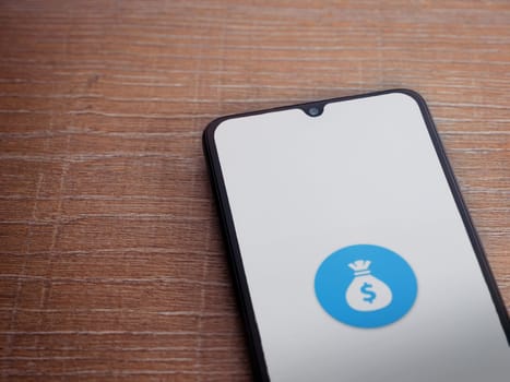 Lod, Israel - July 16,2023: Spender app launch screen on smartphone on wooden background. Top view flat lay with copy space.