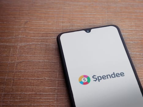 Lod, Israel - July 16,2023: Spendee app launch screen on smartphone on wooden background. Top view flat lay with copy space.