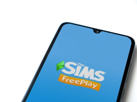 Lod, Israel - July 16,2023: The Sims FreePlay app launch screen on smartphone on white background. Top view flat lay with copy space.
