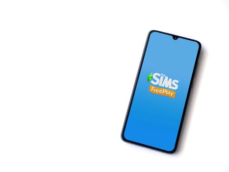 Lod, Israel - July 16,2023: The Sims FreePlay app launch screen on smartphone on white background. Top view flat lay with copy space.