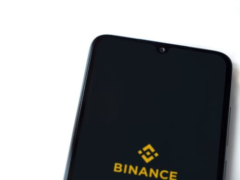 Lod, Israel - July 16,2023: Binance app launch screen on smartphone on white background. Top view flat lay with copy space.