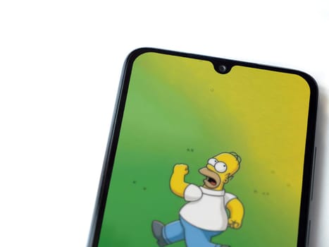Lod, Israel - July 16,2023: The Simpsons Tapped Out app launch screen on smartphone on white background. Top view flat lay with copy space.
