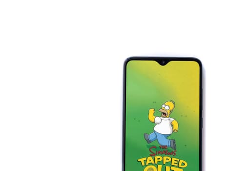Lod, Israel - July 16,2023: The Simpsons Tapped Out app launch screen on smartphone on white background. Top view flat lay with copy space.