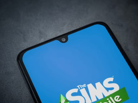 Lod, Israel - July 16,2023: The Sims Mobile app launch screen on smartphone on dark marble stone background. Top view flat lay with copy space.