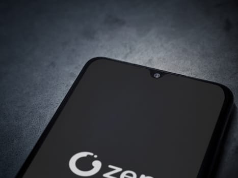 Lod, Israel - July 16,2023: ZEN.COM app launch screen on smartphone on dark marble stone background. Top view flat lay with copy space.