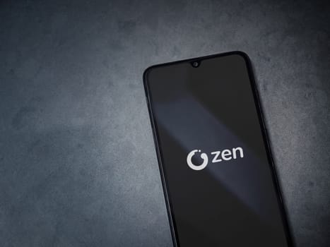 Lod, Israel - July 16,2023: ZEN.COM app launch screen on smartphone on dark marble stone background. Top view flat lay with copy space.