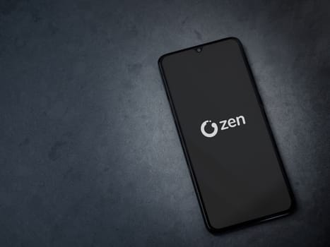 Lod, Israel - July 16,2023: ZEN.COM app launch screen on smartphone on dark marble stone background. Top view flat lay with copy space.