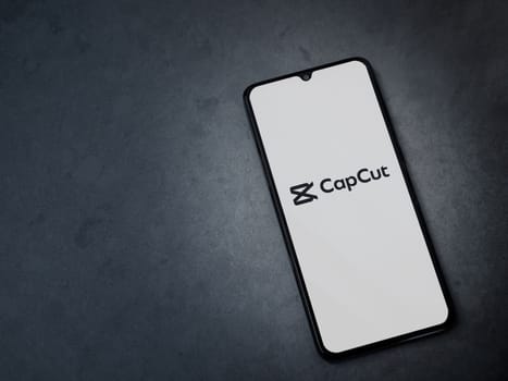 Lod, Israel - July 16,2023: CapCut app launch screen on smartphone on dark marble stone background. Top view flat lay with copy space.