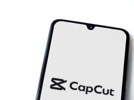 Lod, Israel - July 16,2023: CapCut app launch screen on smartphone on white background.. Top view flat lay with copy space.