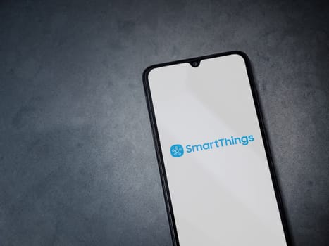 Lod, Israel - July 16,2023: Smartthings app launch screen on smartphone on dark marble stone background. Top view flat lay with copy space.