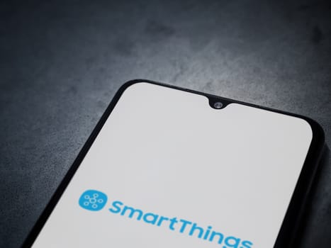 Lod, Israel - July 16,2023: Smartthings app launch screen on smartphone on dark marble stone background. Top view flat lay with copy space.