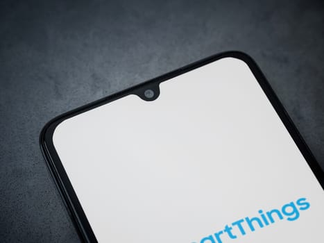 Lod, Israel - July 16,2023: Smartthings app launch screen on smartphone on dark marble stone background. Top view flat lay with copy space.