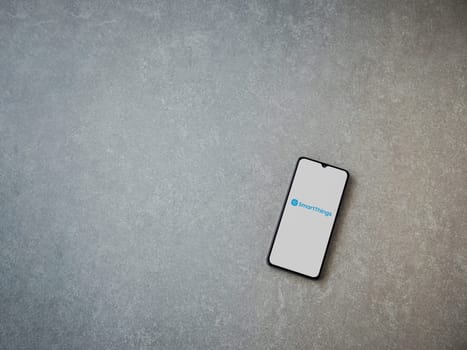 Lod, Israel - July 16,2023: Smartthings app launch screen on smartphone on ceramic stone background. Top view flat lay with copy space.