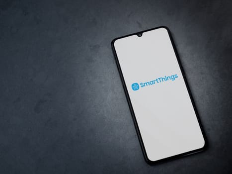 Lod, Israel - July 16,2023: Smartthings app launch screen on smartphone on dark marble stone background. Top view flat lay with copy space.