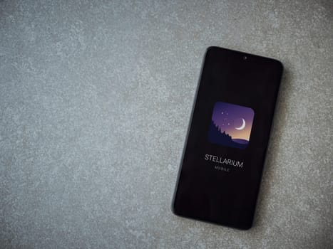Lod, Israel - July 16,2023: Stellarium - Star Map app launch screen on smartphone on ceramic stone background. Top view flat lay with copy space.